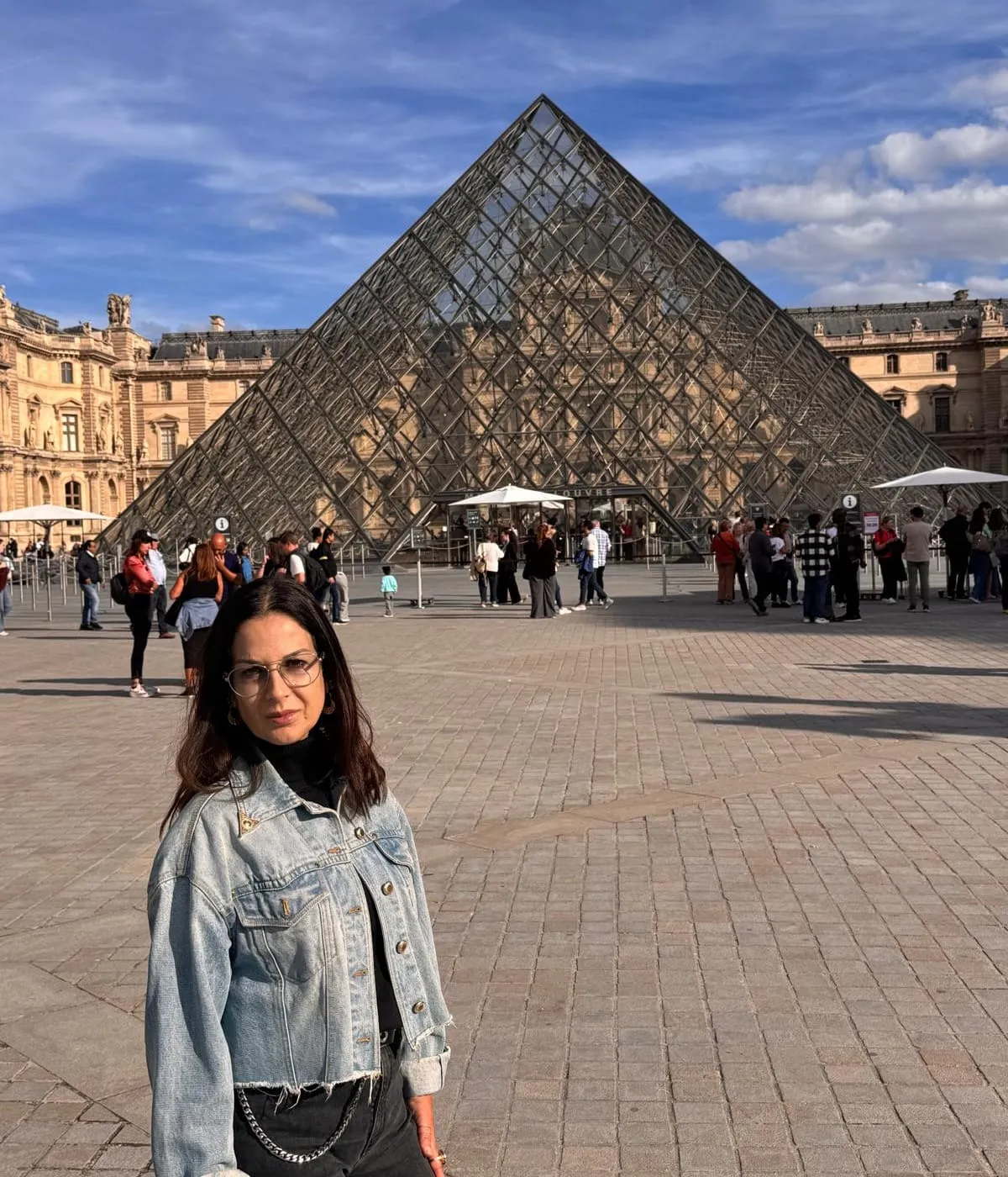 Orlie in front of the Louvre pyramid on a sunny day