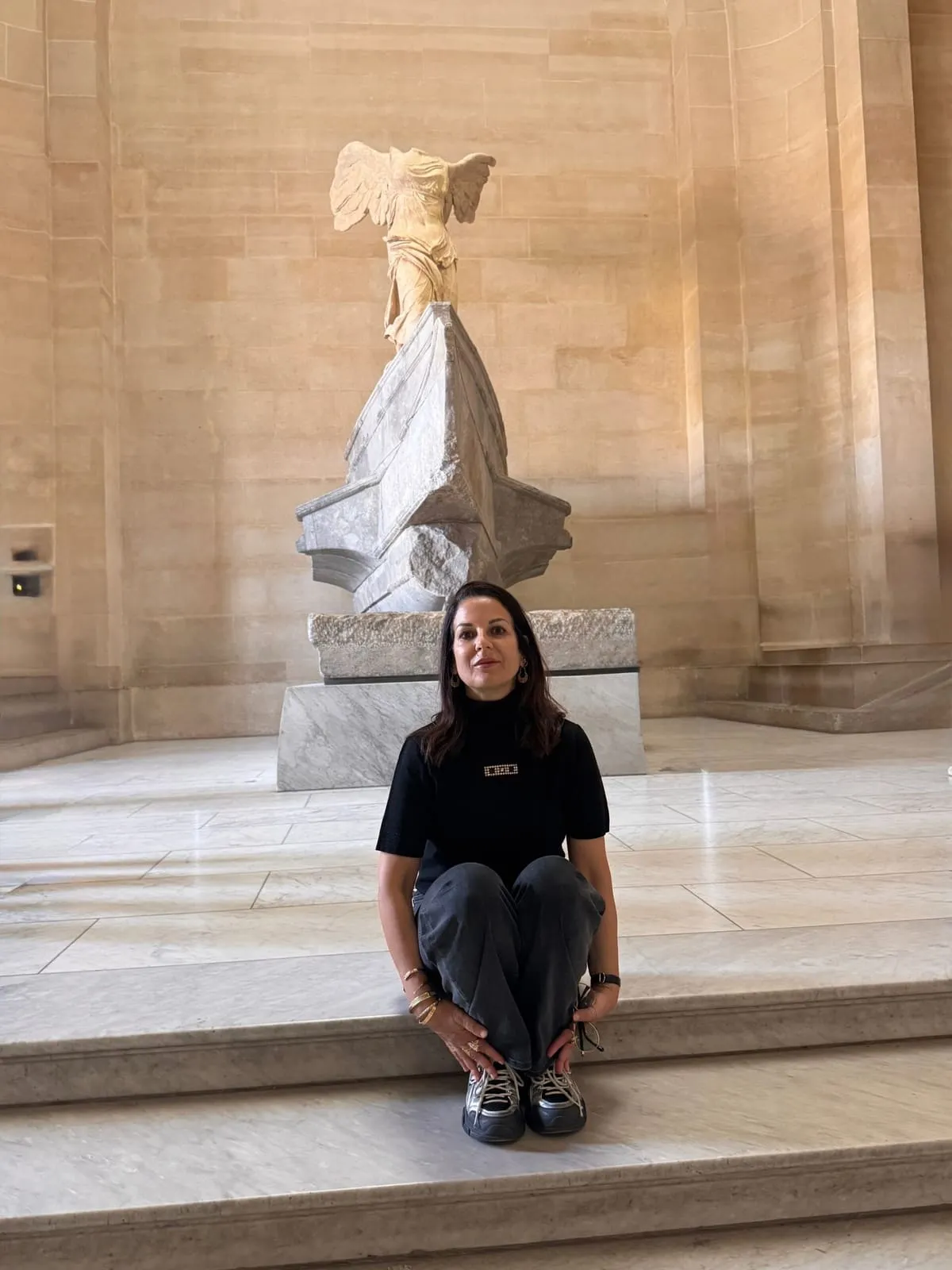 Orlie on the Daru staircase of the Louvre, below the Winged Victory of Samothrace