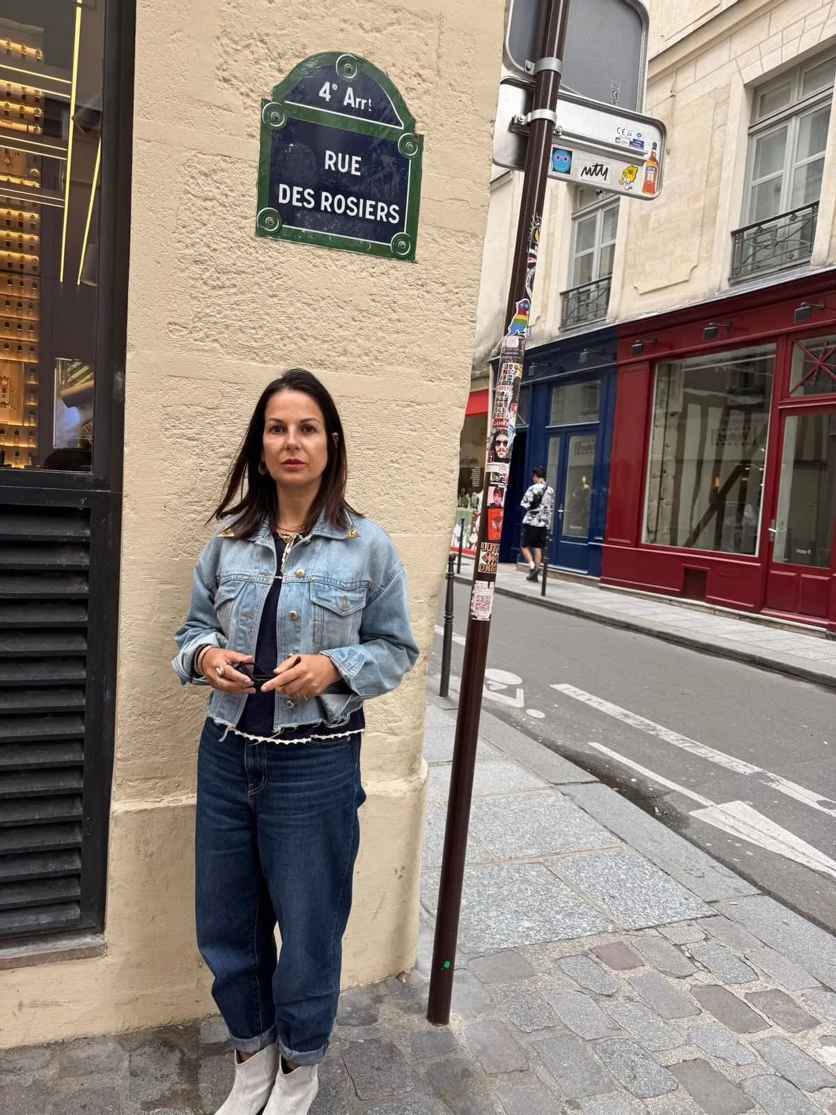 Orlie under the rue des Rosiers street sign, in the heart of the Pletzl